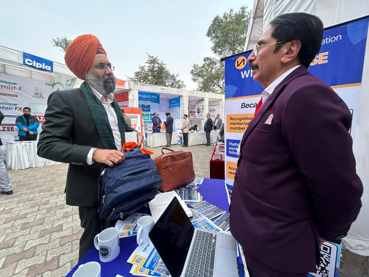 Conversation at an exhibition stand displaying GeNext materials